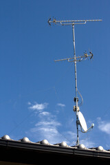 住宅の屋根の上のテレビのアンテナ