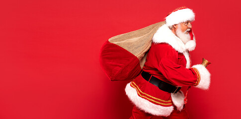 Funny Santa Claus holding sack bag with Merry Christmas presents.