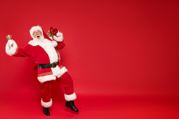 Fototapeta na wymiar Funny Santa Claus holding sack bag with Merry Christmas presents.