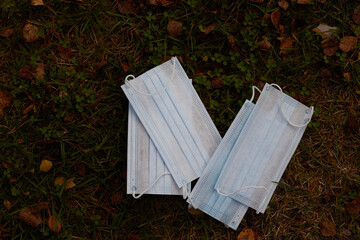 medical disposable mask against the yellow leaves in autumn