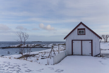 house by the sea with everything snowed in Lofoten