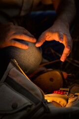 mão buscando por algo dentro da mochila com luz de vela