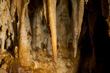 Stalactites and stalagmites inside natural limestone cave. Natural formations.