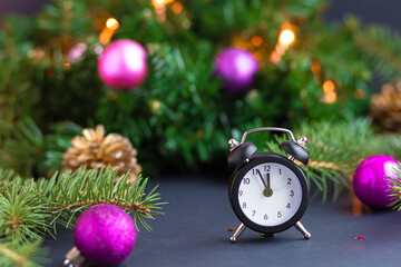 black table clock shows 12.00 pm at night on the background of Christmas decorations. chime chimes...