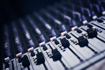 Sound recording director's console. Remote audio engineer. Many buttons of grey audio mixer board console for sound producer. Music equipment. Close-up. Mixer for musician DJ. Night club concept.