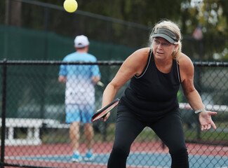 Obraz premium Senior woman competes in a pickleball tournament.