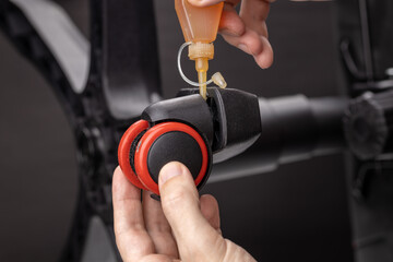 repair office armchair. worker lubricating rolling elements. diy concept