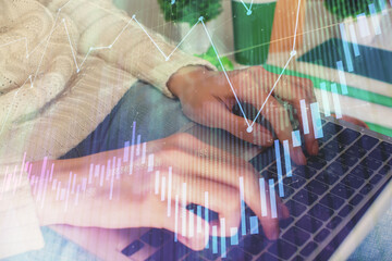 Fototapeta premium Double exposure of woman hands typing on computer and forex chart hologram drawing. Stock market invest concept.