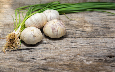 Garlic bulb and leaves on old wooden background
