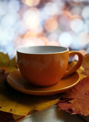 Autumnal composition orange coffee mug on rusty leaves and bokeh background.  Sellective focus on mug, depth of field. Relaxing at home and hygge concept.