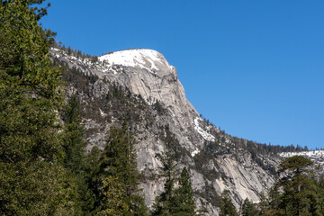 Mountain Landscape at Yosemite Park with Blue Sky, Green Pine Trees and Snow.