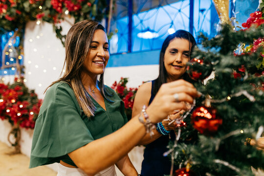 Christmas in Brazil. Two women decorating the Christmas tree