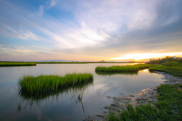 Fototapeta na wymiar Sunset reflection with marsh grass waterway on the coast 