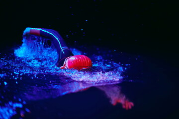 real triathlon athlete swimming in dark night