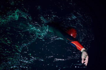 real triathlon athlete swimming in dark night