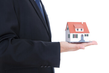 Man in black suit holds small house model