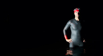 Fototapeta na wymiar authentic triathlete swimmer having a break during hard training on night
