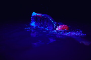 real triathlon athlete swimming in dark night