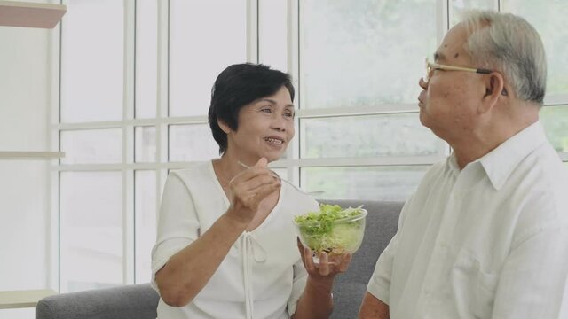 Family concept. Old couple happily eating vegetable salad. 4k Resolution.