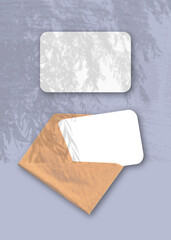 An envelope with two sheets of textured white paper on the violet background of the table. Mockup...