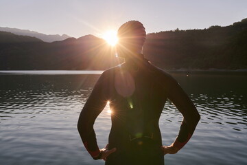 triathlon athlete starting swimming training on lake