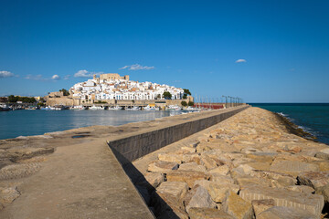 Fototapeta na wymiar Peniscola harbor from the breakwater with the castle and the walled precinct in the background, Castellon, Spain
