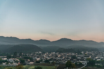  Panorama view of Xidi village, an ancient Chinese village in Anhui Province, China, a UNESCO world cultural heritage site, shot at sunrise with fog in the mountains.