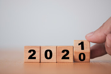 Hand flipping wooden blocks for change year  2020 to 2021 . New year and holiday concept.