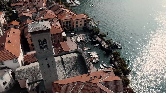 Aerial View Of The Parish Of Saint Tecla At The Shore Of Lake Como In Torno, Como, Italy - orbiting drone shot
