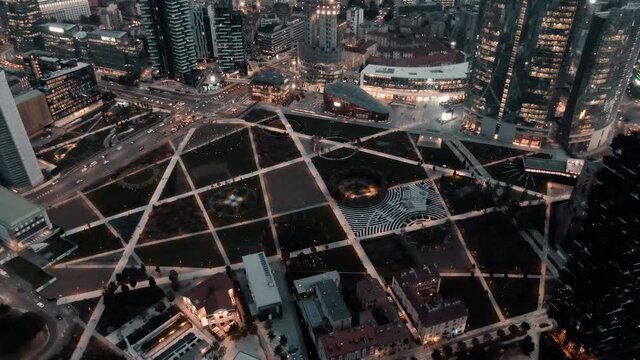 Library Of Trees And Lido Bam Surrounded By The Downtown Skyline Illuminated At Night - Garden Park And Botanical Garden In Milan, Italy.  - aerial drone shot