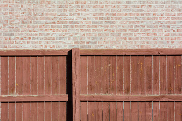Textured background of brown weathered wooden fence and brick wall