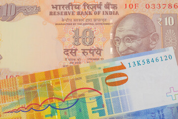 A macro image of a orange ten rupee bill from India paired up with a yellow Swiss ten franc bill.  Shot close up in macro.