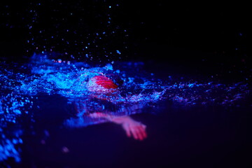 real triathlon athlete swimming in dark night