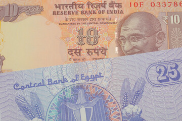 Fototapeta premium A macro image of a orange ten rupee bill from India paired up with a blue twenty five piastre bank note from Egypt. Shot close up in macro.
