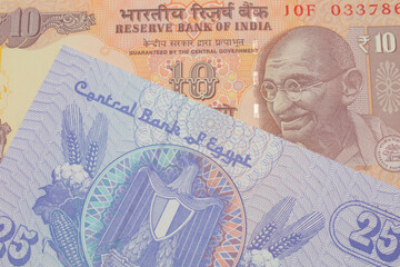 A macro image of a orange ten rupee bill from India paired up with a blue twenty five piastre bank note from Egypt.  Shot close up in macro.