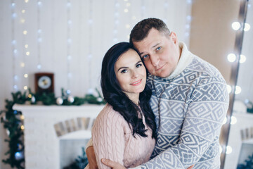 Fototapeta premium The family celebrates Christmas together. A couple in love hugs