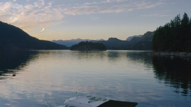 Speedboat Floating On The Calm Waters Of Sechelt Inlet On A Sunset - A Pacific Ocean Fjord Near The Egmont In Sunshine Coast, British Columbia, Canada. - aerial drone shot