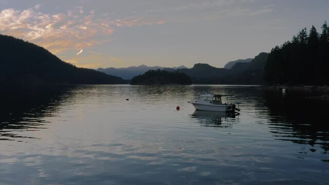 Lone Boat Mooring By The Calm Water With Beautiful Sunset Views Of Sechelt Inlet - A Pacific Ocean Fjord On The Sunshine Coast Near Egmont, British Columbia, Canada - Medium Shot