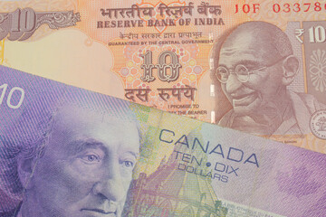 Fototapeta premium A macro image of a orange ten rupee bill from India paired up with a purple ten dollar bill from Canada. Shot close up in macro.