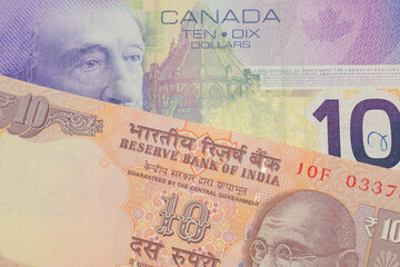 A macro image of a orange ten rupee bill from India paired up with a purple ten dollar bill from Canada.  Shot close up in macro.