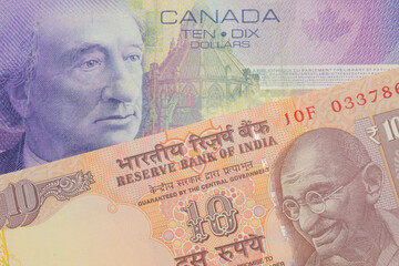 A macro image of a orange ten rupee bill from India paired up with a purple ten dollar bill from Canada.  Shot close up in macro.