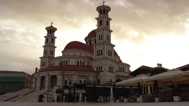 Cathedral of Korca in Albania with fountains on paved square at cloudy morning
