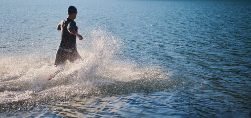 Fototapeta premium triathlon athlete starting swimming training on lake
