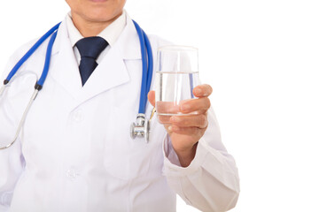 A doctor in a white coat is holding a glass of white water