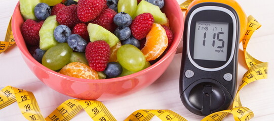 Fresh fruit salad, glucose meter and centimeter, diabetes, healthy lifestyle and nutrition concept