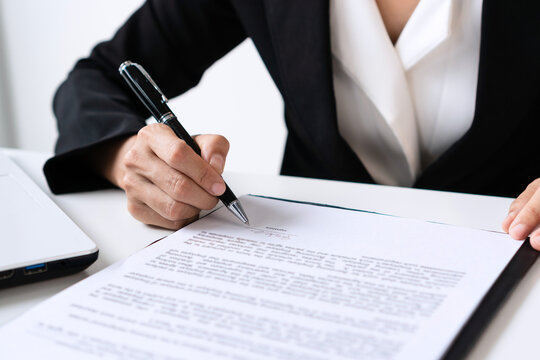 Closeup of Asian businesswoman signing contract or document at office. Business concept.