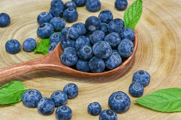 fresh blueberries in a wooden spoon over wooden table