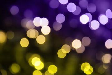 Obraz premium Christmas lights. Bokeh glows on a dark background. Christmas garlands with blurred focus in the form of yellow and purple bokeh.
