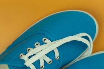 White laces on blue sneakers on a yellow background