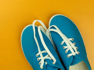 White laces on blue sneakers on a yellow background